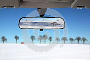 Snow Landscape reflected in car rear mirror