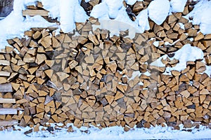 Snow log stack lumber in winter. Woodpile of pine