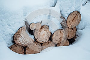 Snow log stack lumber in winter. Woodpile of pine