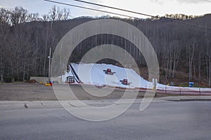 Snow machines make grade snow on a mountain side for snow sledding