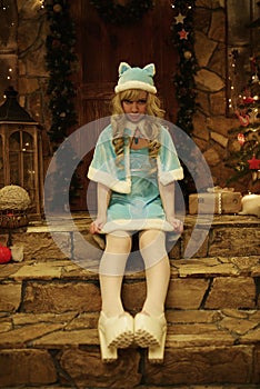 Snow Maiden on doorstep of house decorated in Christmas style