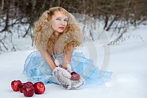 Snow Maiden in a winter forest with apples