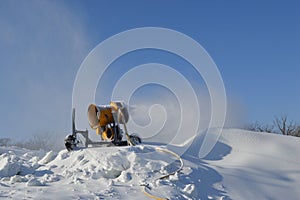 Snow making machine, named snow cannon or snow gun making snow for snowboarding, skiing in mountains.