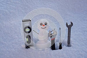 Snow man. Repairman with repair tools. Support repair and recover service. Happy smiling snowman on sunny winter day.