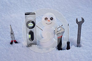 Snow man. Repairman with repair tools. Support repair and recover service. Snowman on the background of snowflakes