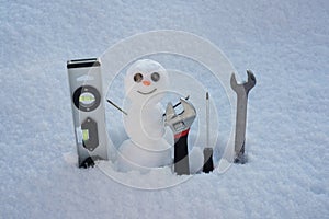 Snow man in winter. Repairman with repair tools. Support repair and recover service. Christmas snowman. New year element