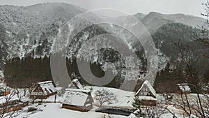 Snow and mist moves over Gokayama village in snowy mountain landscape