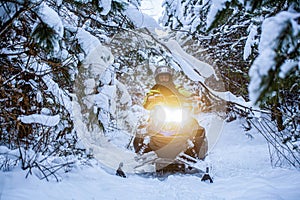 Snow mobile scooter atv vehicle forest road. Arctic nordic snow sledge transport. Man is riding snowmobile in mountains