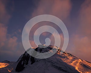 Snow mountain at sunset with some clouds.