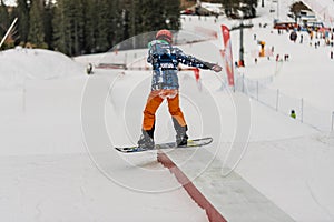 Children in snowpark in Dolomites Alps. Snow park box tricks. Snowboarder in park on a box. Winter jibbing in snwopark. Snowboard photo