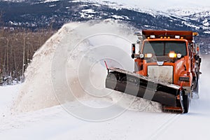 Snow plough clearing road in winter storm blizzard photo