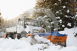 Snow plough making its way through the snowy country road