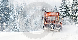 Snow plow on highway salting road . Orange truck deicing street. Maintenance winter gritter vehicle wide panorama or banner