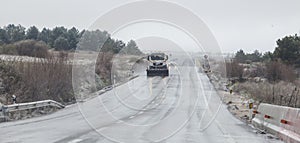 Snow plow patrolling the road in a sleet