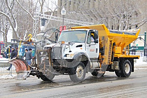 Snow plow and road deicer in winter