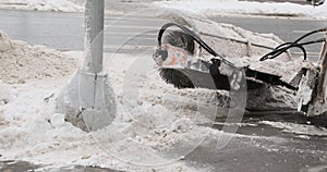 Snow plow with a round brush cleans the roadway, automobile road
