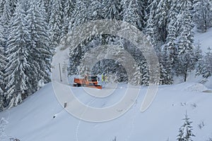 Snow plow truck cleaning snowy road in snowstorm