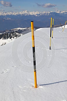 Snow poles have been positioned along the side of the road to delimit the edge of the asphalt