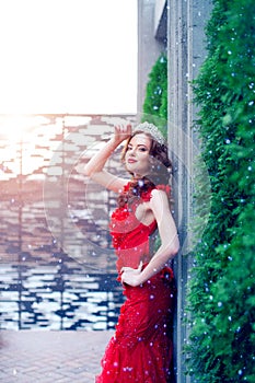 Snow Queen in red. Winter woman in crown in a red dress and red