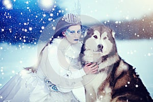 Snow queen in winter. Fairy tale girl with Malamute.
