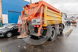 Snow removal equipment sprinkling the road with sand and salt