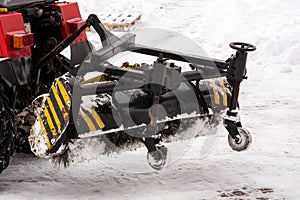 Snow removal equipment in work. Cleaning the streets of snow with a tractor