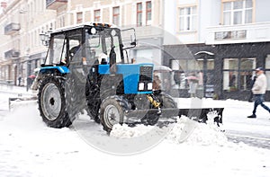 Snow removal machine cleaning the street from snow. Snowplow truck removing snow on the street after blizzard