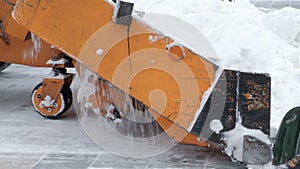 Snow removal on the streets. Close-up of a snowplow and road workers with shovels. People and cars. Abundance of snow. Winter.