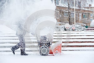 Snow-removal work with a snow blower. Man Removing Snow. heavy precipitation and snow piles.