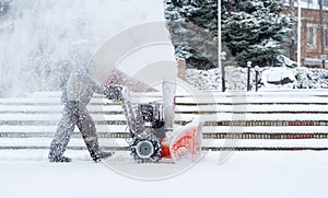 Snow-removal work with a snow blower. Man Removing Snow. heavy precipitation and snow piles.