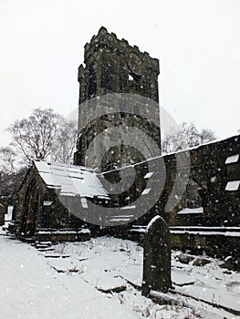 The snow on ruined medieval church in heptonstall with graveyard
