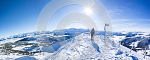 Snow shoe hiker a the summit of the snowy mountain. panoramic picture of winter hiker at the top of the hill. gorgeous swiss alps