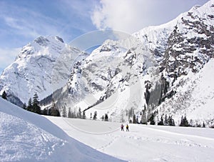 Snow, skiers and mountain backdrop