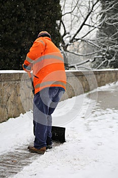 Snow spreader with high visibility jacket in winter