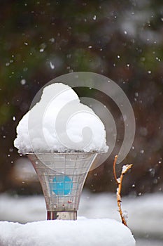 Snow on Street Lamp looking like Icecream Cone with White Snow Flakes in Air - Active Snowfall during Winter