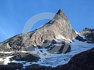 Snow summit, rocky mountain peaks and glacier in Norway