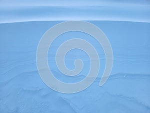Snow texture. The wind in the tundra and in the mountains sculpts patterns and ridges on the snow surface. Winter