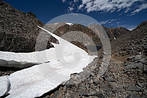 Snow on the trail of the 20 Lakes Basin hiking trail in the Eastern Sierra Nevada Mountains in Mono County California