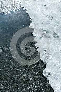 Snow on wet sidewalk in spring time
