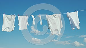 White linen dries on a rope against a clean blue sky
