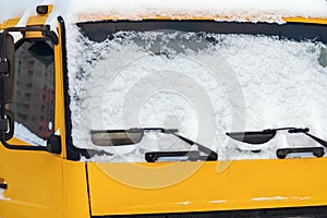 Snow on the windshield of a yellow truck