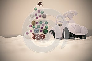 Snow xmas tree and toy car on grey sky