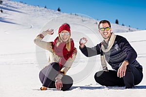 Snowball fight. Winter couple having fun playing in snow outdoors. Young joyful happy multi-racial couple.