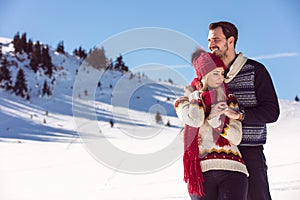 Snowball fight. Winter couple having fun playing in snow outdoors. Young joyful happy multi-racial couple.