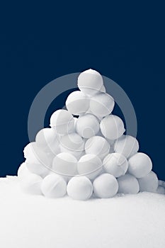 Snowballs pyramidal heap on dark blue background