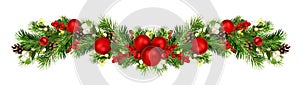 Snowberries with green twigs of Christmas tree, red decorations and cones in a holiday waved garland isolated on white background