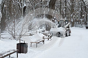 Snowblower cleans sidewalks. Russian Winter. Snow removal.