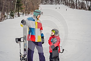 Snowboard instructor teaches a boy to snowboarding. Activities for children in winter. Children`s winter sport