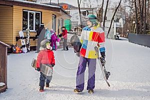 Snowboard instructor teaches a boy to snowboarding. Activities for children in winter. Children`s winter sport