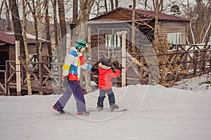 Snowboard instructor teaches a boy to snowboarding. Activities for children in winter. Children`s winter sport